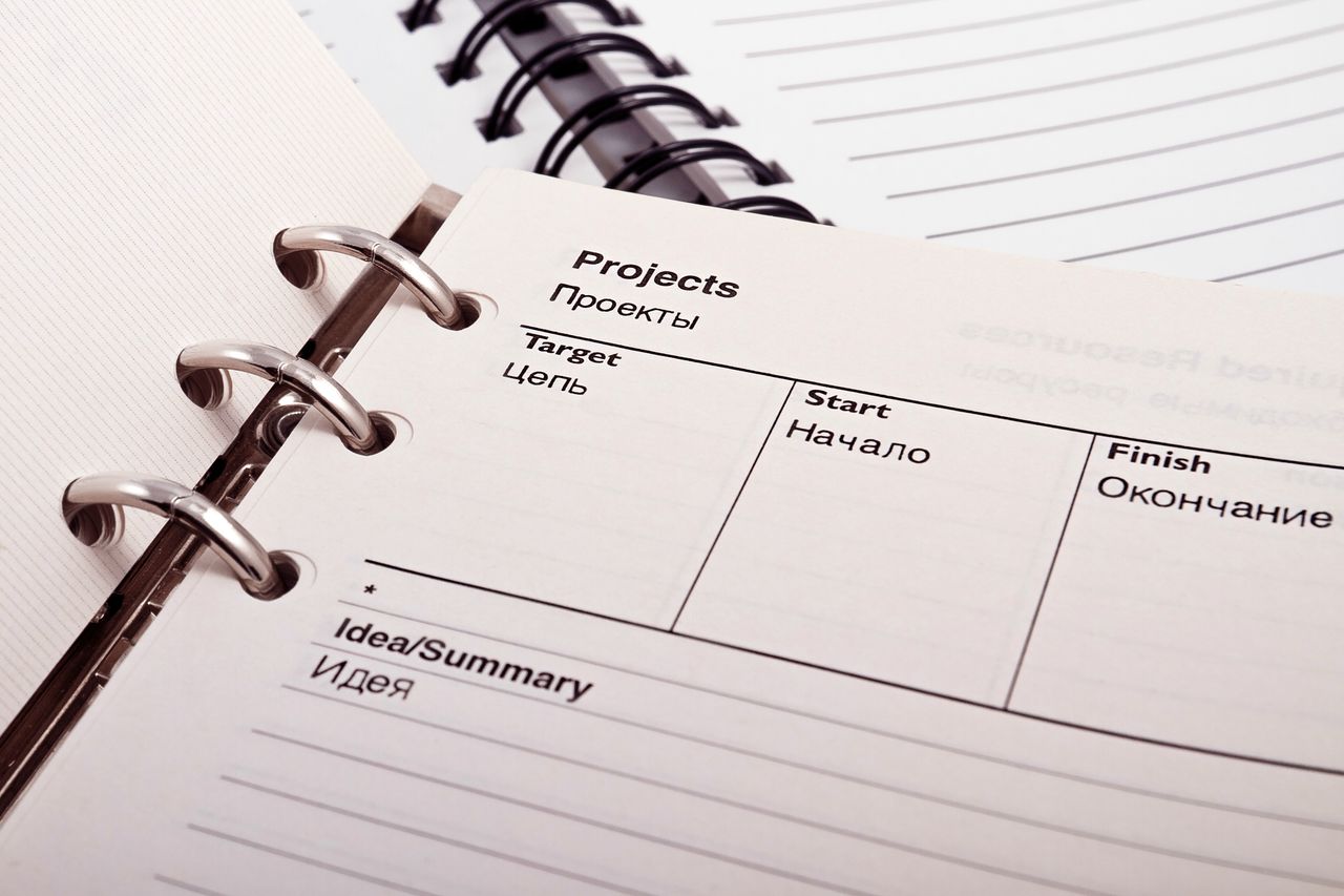 Crafting Captivating Headlines: Your awesome post title goes here Open planner displaying project schedule with Russian-English text, ideal for office or educational content.