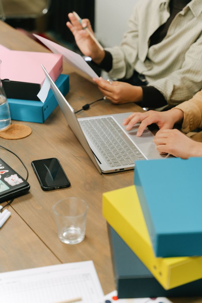 Mastering the First Impression: Your intriguing post title goes here Business colleagues discussing project at office desk with laptop and documents.